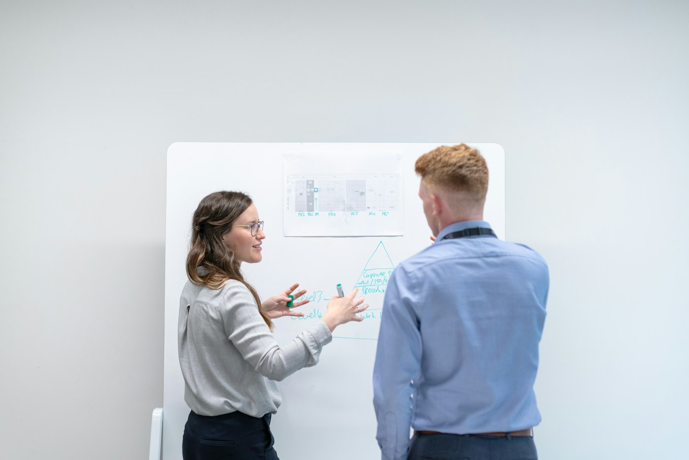 Deux collègues travaillent devant un tableau blanc